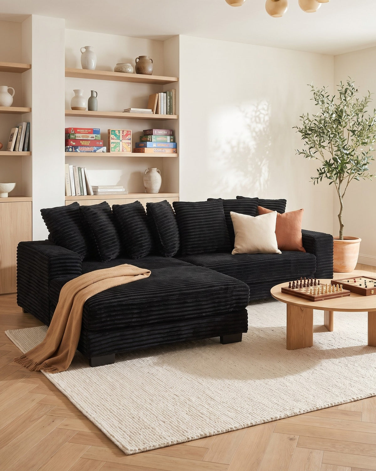 Black Corduroy L-Shaped Sectional with Reversible Chaise, 111 in in Black, chaise shown on the left (reversible), styled in a bright living room