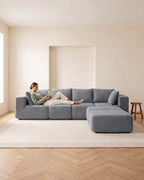 Boneless U-Shaped Sectional with Two Ottomans, 116 in in Dark Grey, with a person relaxing on it [c:darkgrey] [r:comfort]