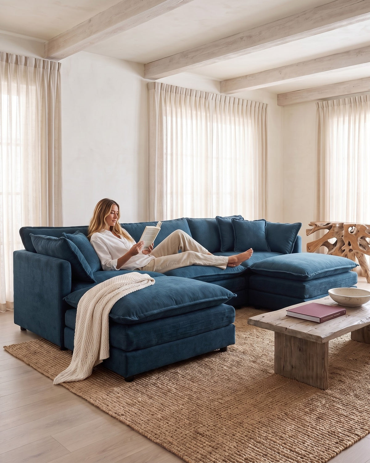 Chenille U-Shaped Sectional with 2 Reversible Ottomans, 3 Seats in Blue, with a person relaxing on it