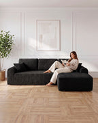 Cloud Modular L-Shaped Sectional with Chaise, 109 in in Black, chaise on the left, with a person relaxing on it [c:black] [r:comfort]