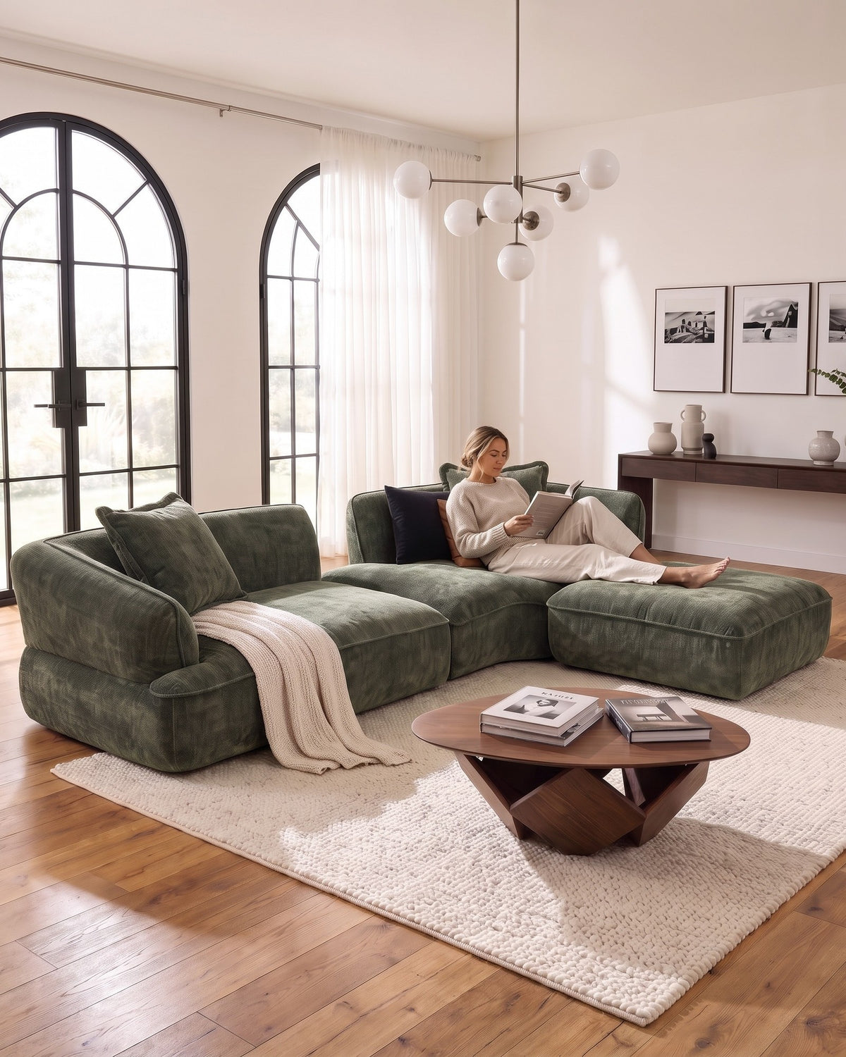 Woman reading on the Compressed L-Shaped Sectional with Chaise, 122 in in Green, legs on the ottoman