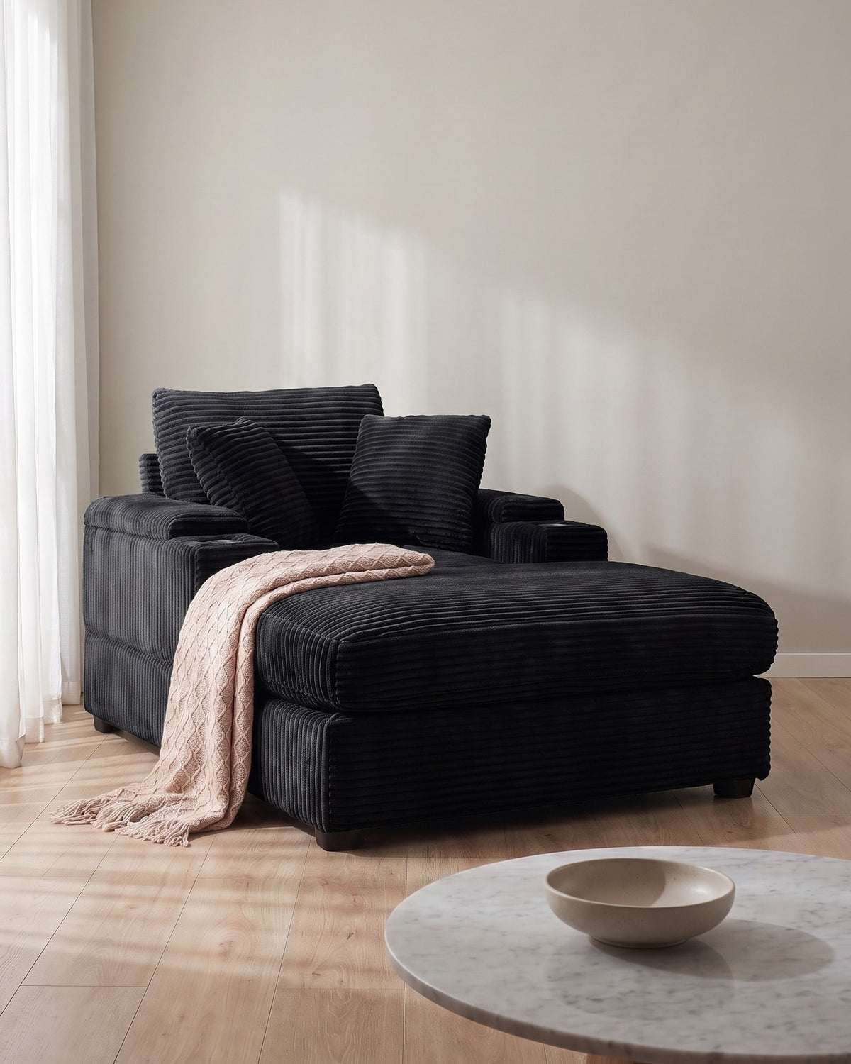 Corduroy Chair and a Half with Storage Arms and Ottoman in Black, styled in a bright living room