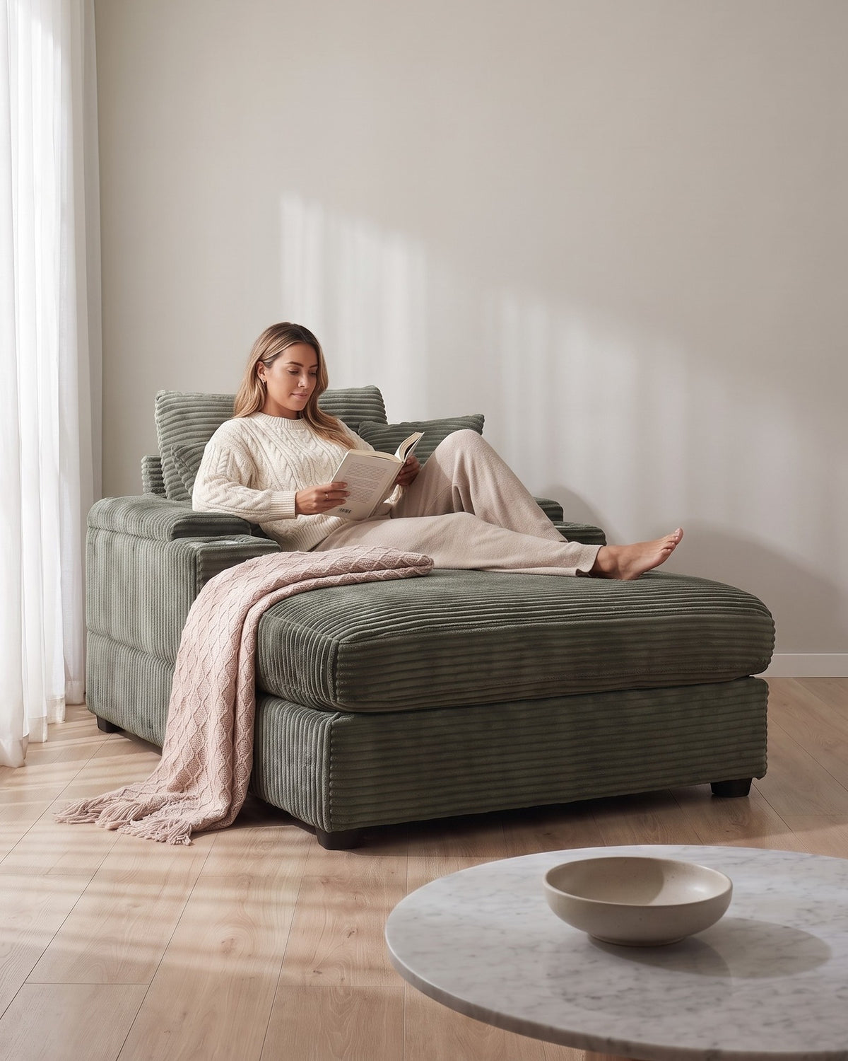 Corduroy Chair and a Half with Storage Arms and Ottoman in Dark Green, with a person relaxing on it