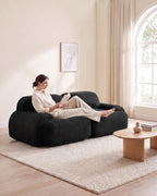 Corduroy Modular Loveseat, 82 in in Black, with a person relaxing on it [c:black] [r:comfort]