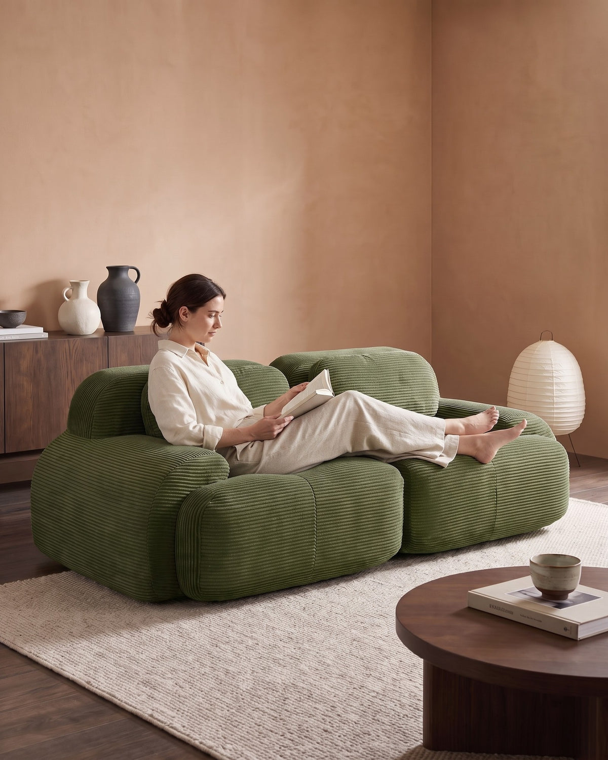 Corduroy Modular Loveseat, 82 in in Olive Green, with a person relaxing on it