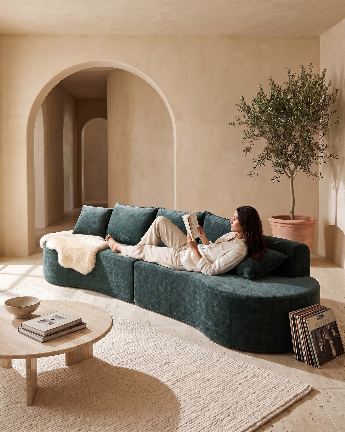 Curved Sectional, 139 in in Dark Green, with a person relaxing on it