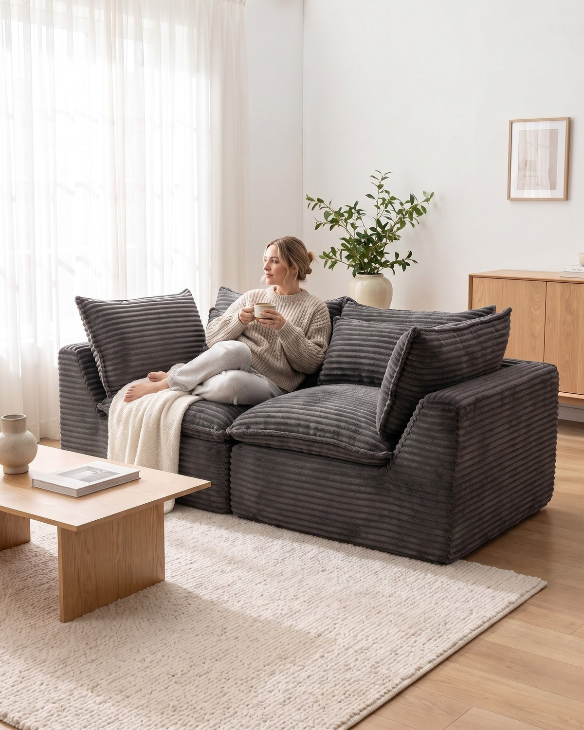 Oversized Cloud Loveseat, 75 in in Antique Grey, with a person relaxing on it