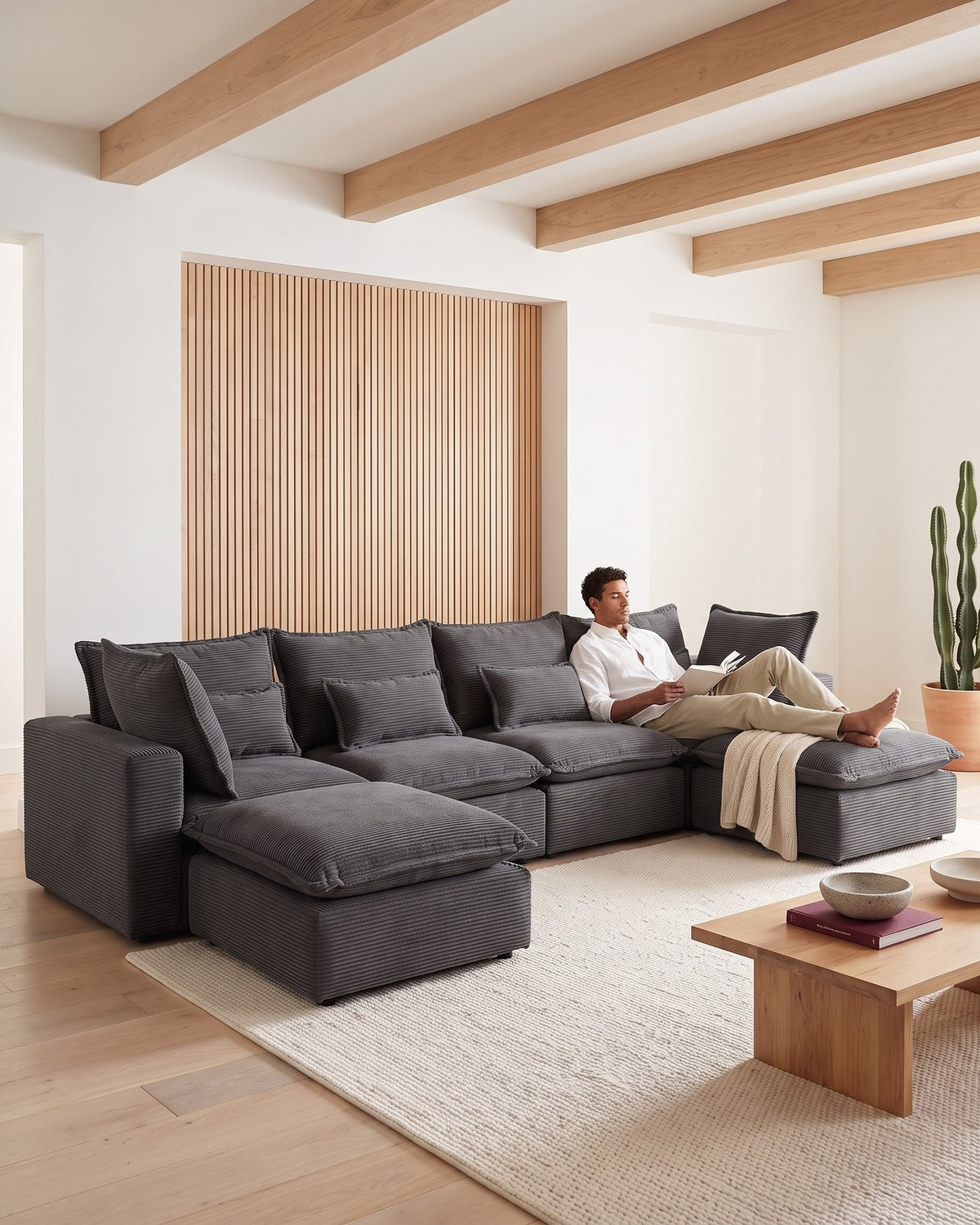 Oversized Cloud U-Shaped Sectional with Ottomans, 130 in in Antique Grey, with a person relaxing on it