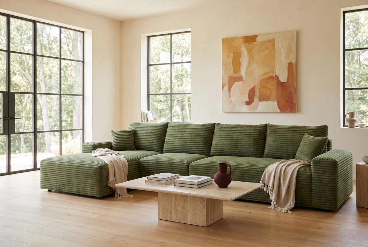 Green corduroy L-shaped modular sectional with a chaise in a sunlit living room