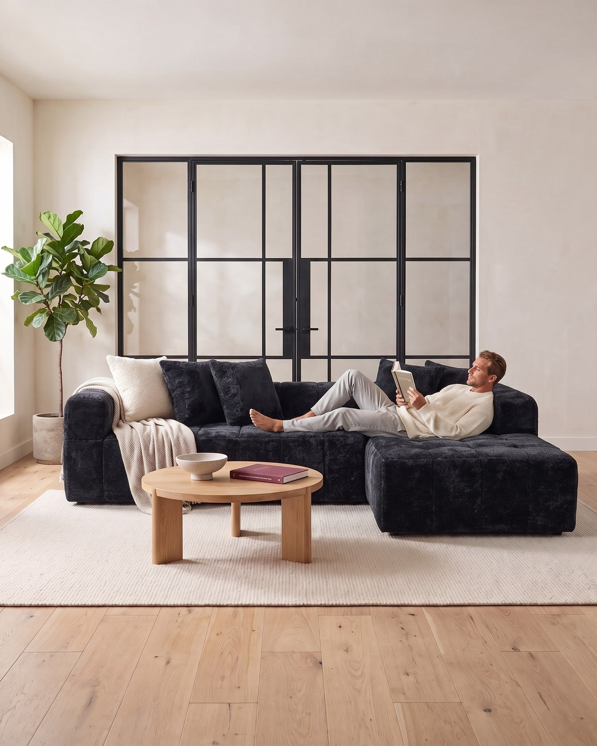 Textured Cloud L-Shaped Sectional with Chaise, 108 in in Black, with a person relaxing on it