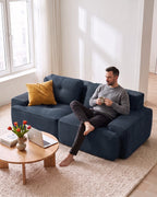 Tufted Corduroy Loveseat, 82 in in Blue, with a person relaxing on it [c:blue] [r:comfort]