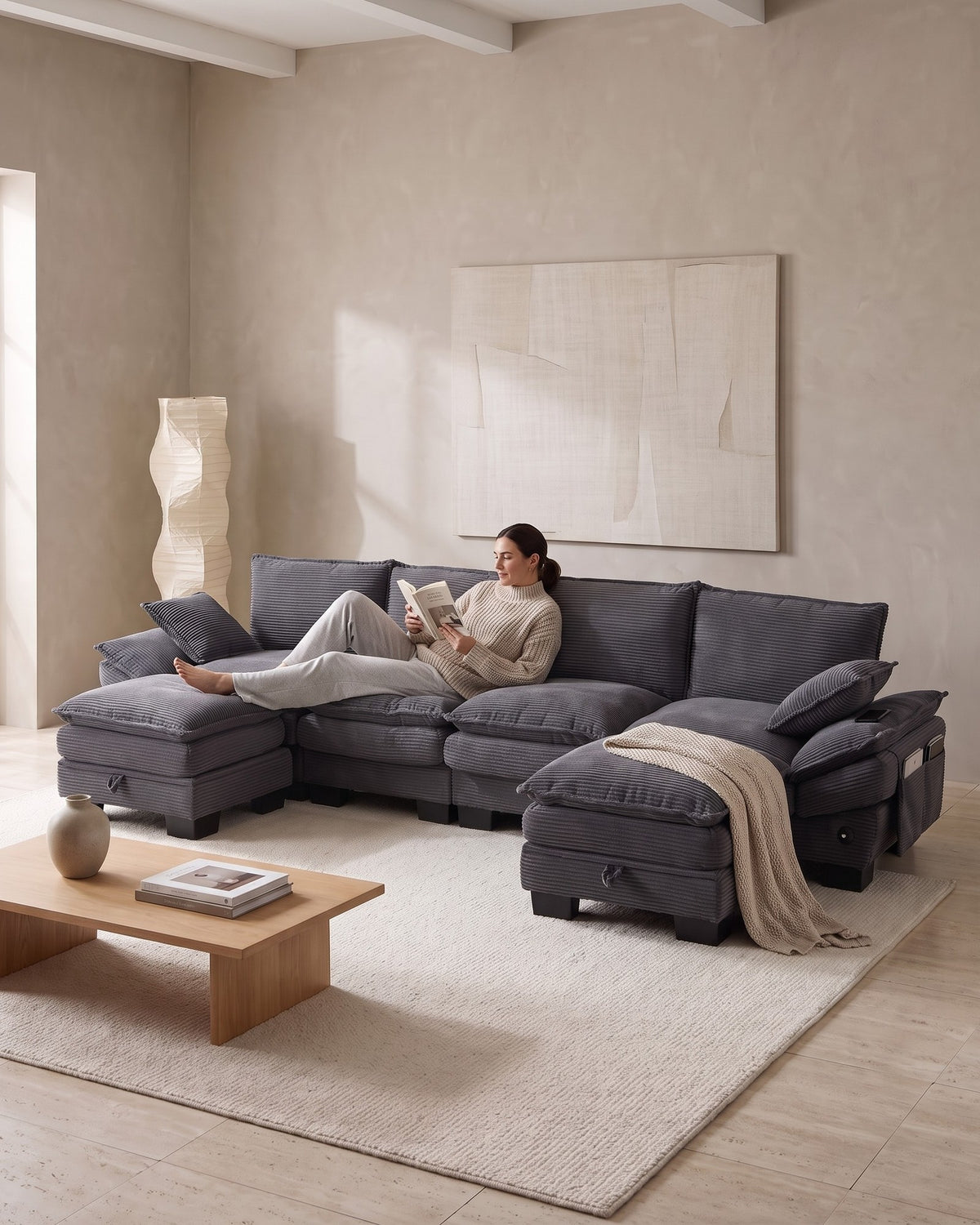 U-Shaped Corduroy Cloud Sectional with 2 Storage Ottomans, 130 in in Dark Grey, with a person relaxing on it