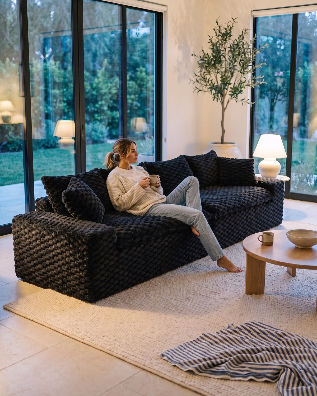 Velvet Modular Sofa, 4 Seats, 120 in in Black, with a person relaxing on it