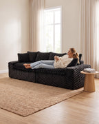 Velvet Modular Sofa, 4 Seats, 120 in in Black, with a person relaxing on it [c:black] [r:comfort]